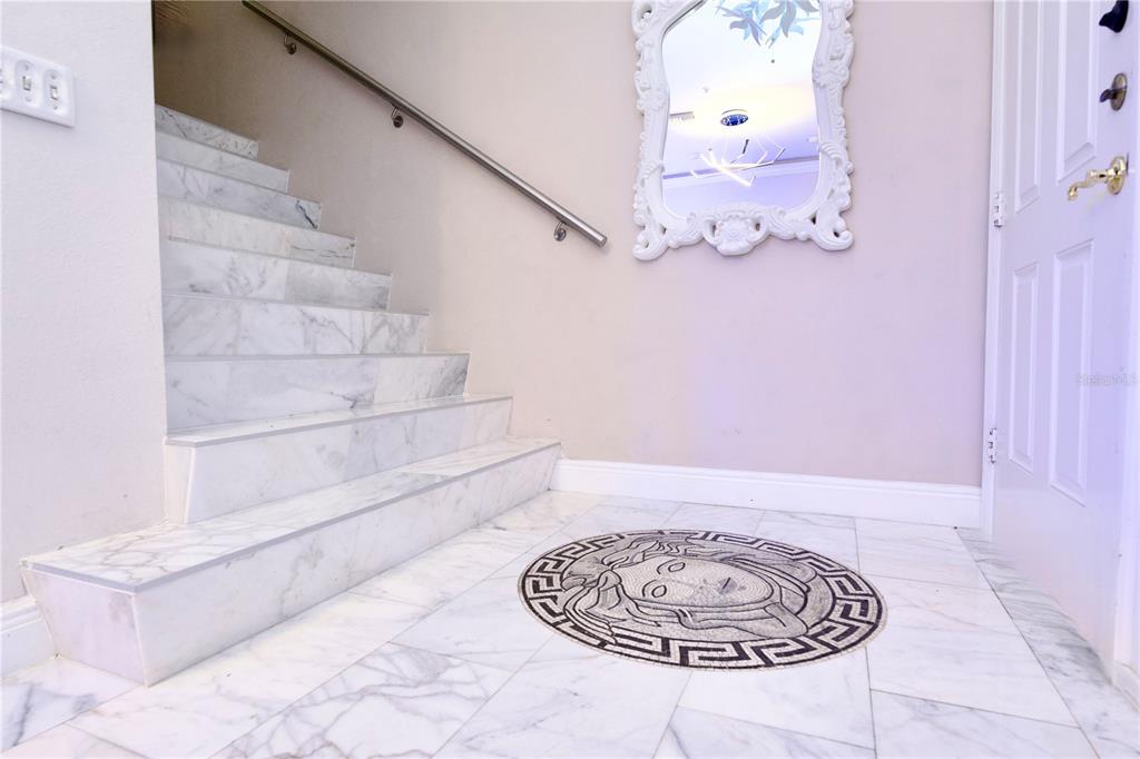 A marble staircase and floor with a circular mosaic medallion in a home entryway — 1437 HARBOUR WALK ROAD, TAMPA, FL