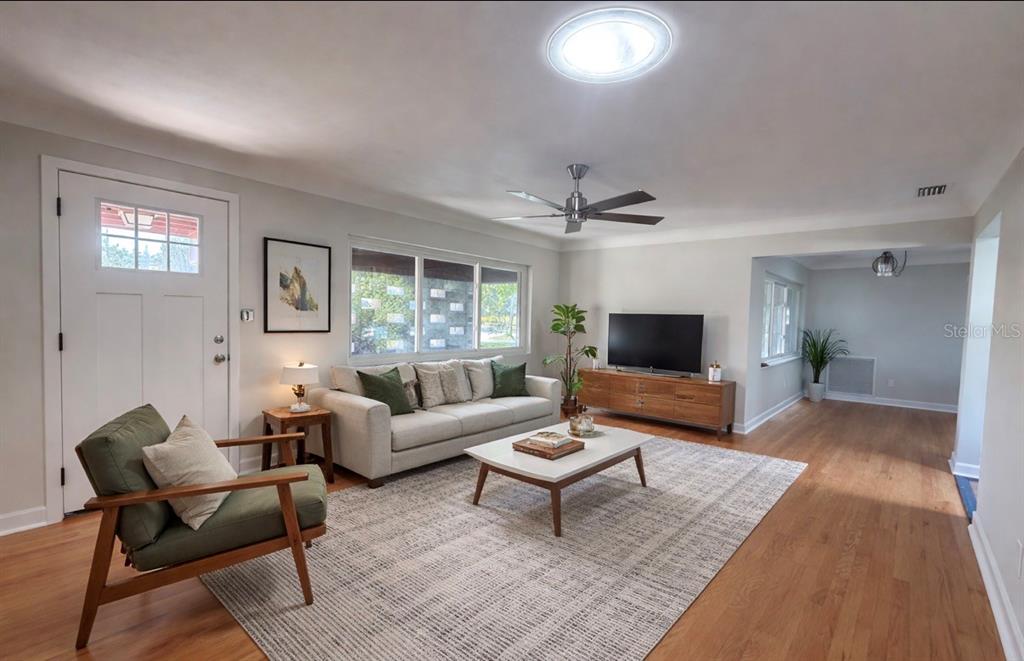 A living room features a sofa, armchair, coffee table, television, and hardwood floors — 6221 6TH AVENUE N, ST PETERSBURG, FL