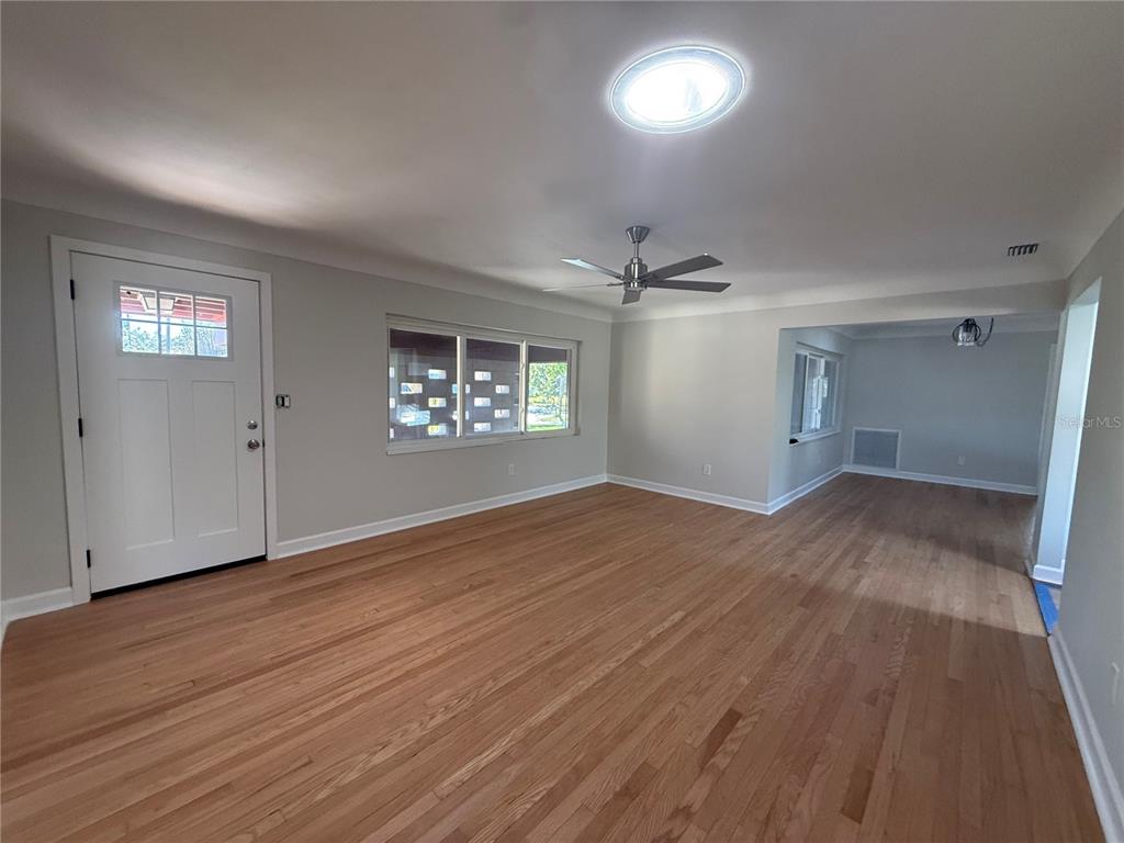 A living room features hardwood floors, a ceiling fan, a skylight, and a front door — 6221 6TH AVENUE N, ST PETERSBURG, FL