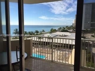 A balcony view overlooking a swimming pool, palm trees, and the ocean — 1950 S Ocean Dr # 5L, Hallandale Beach FL 33009, HALLANDALE BEACH, FL