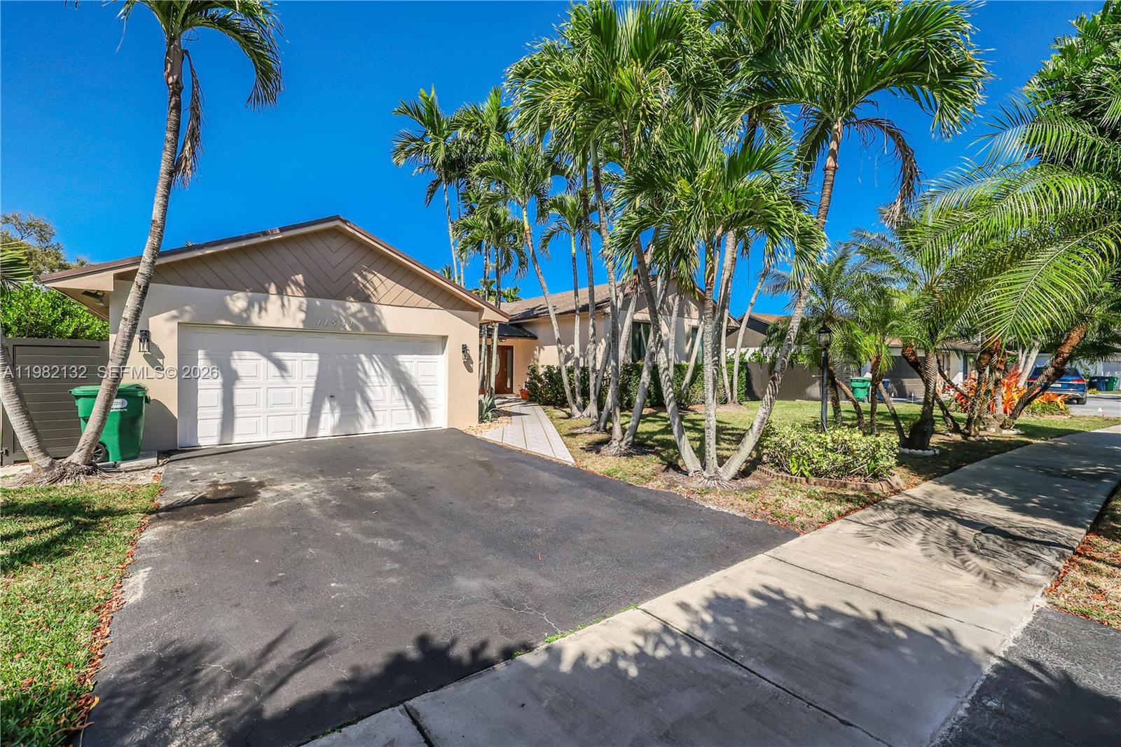 A single-story house with a two-car garage, a paved driveway, and several palm trees — 11541 SW 100th St, Miami FL 33176, MIAMI, FL