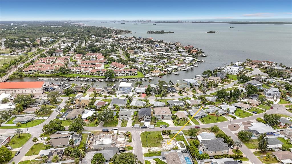 An aerial view shows a vacant residential lot in a coastal neighborhood near the water — 2464 DEL RIO WAY, DUNEDIN, FL