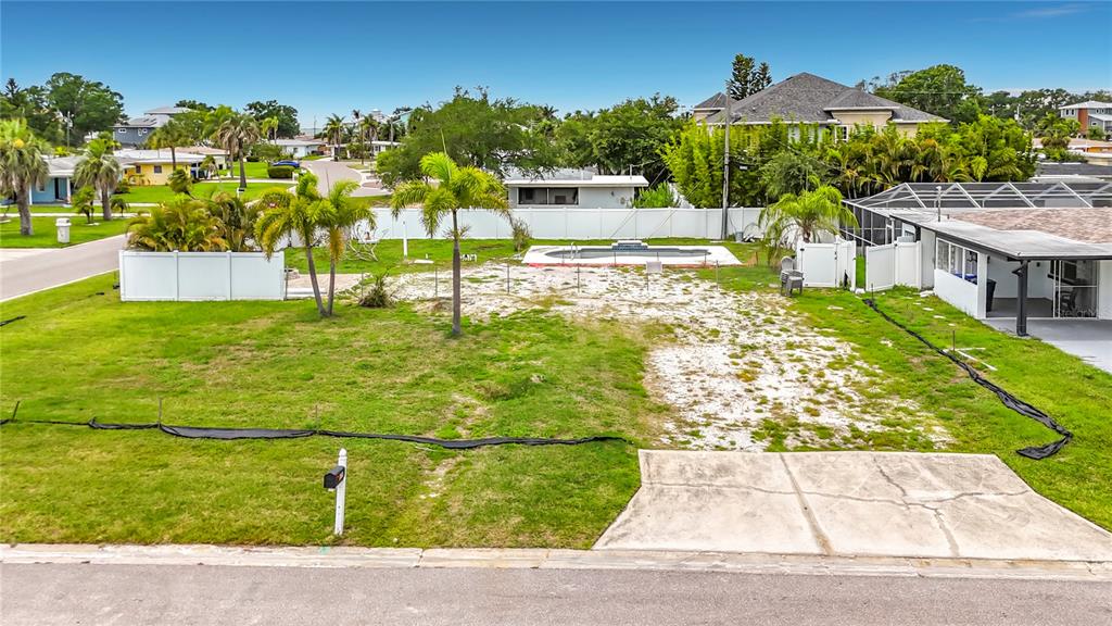 An empty residential lot features a swimming pool, palm trees, and a concrete driveway — 2464 DEL RIO WAY, DUNEDIN, FL