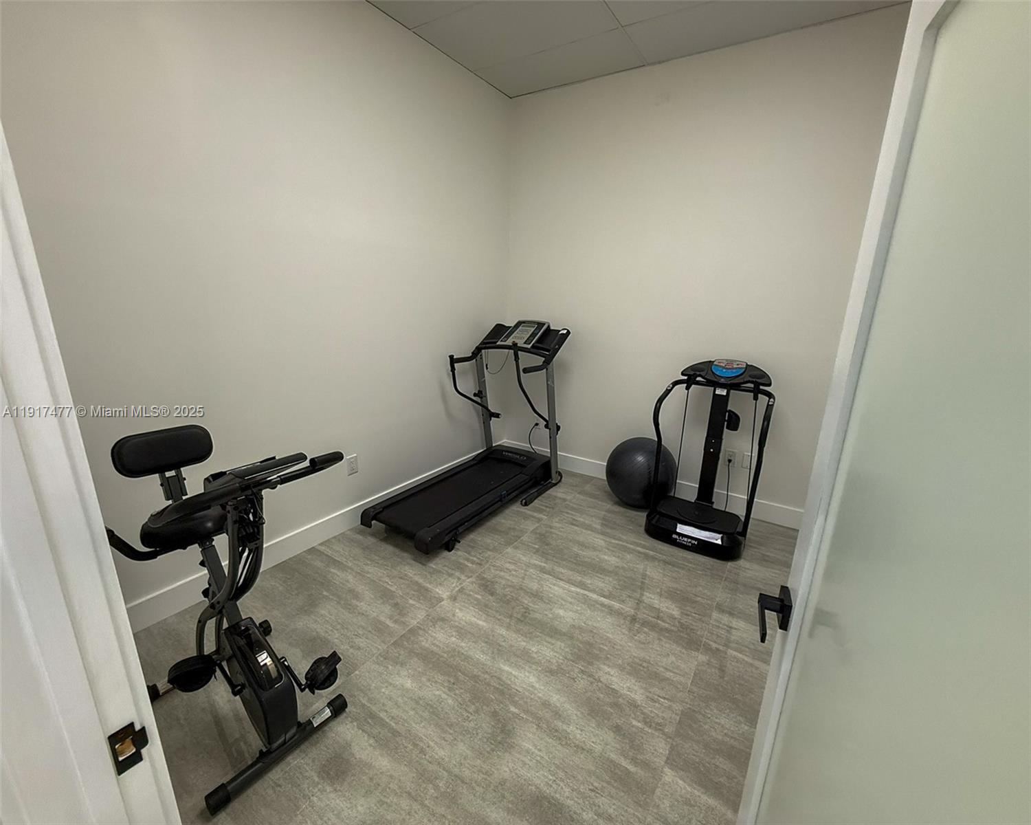 A small home gym features a treadmill, exercise bike, vibration plate, and exercise ball — 9447 SW 56th St # 49, Miami FL 33165, MIAMI, FL