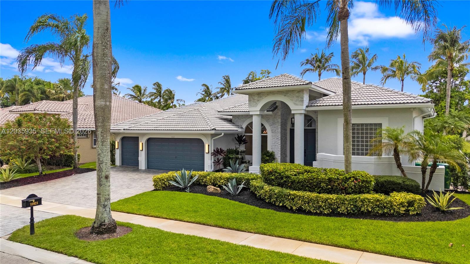 A single-story house with a gray tile roof, arched entryway, and a three-car garage — 11021 Redhawk St, Plantation FL 33324, PLANTATION, FL
