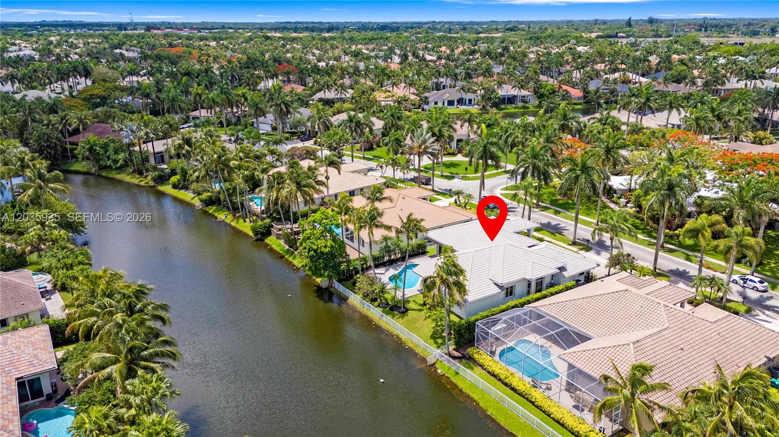 An aerial view shows a waterfront house with a pool and a red location pin — 11021 Redhawk St, Plantation FL 33324, PLANTATION, FL