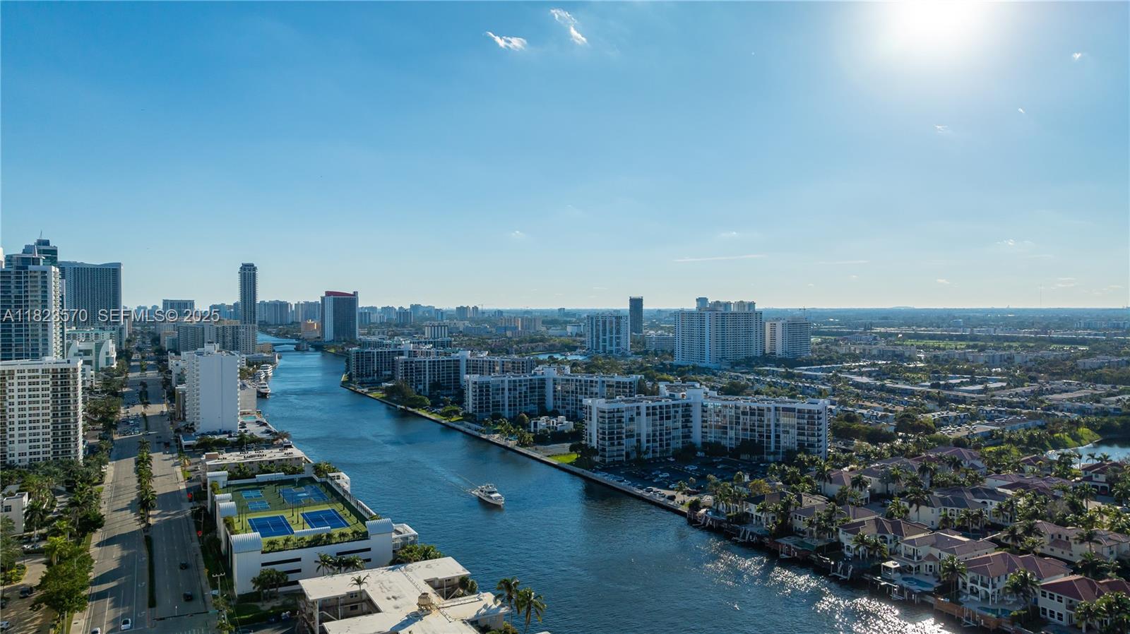 An aerial view shows a waterway lined with residential buildings, tennis courts, and city skyscrapers — 2101 S Ocean Dr # 2707, Hollywood FL 33019, HOLLYWOOD, FL