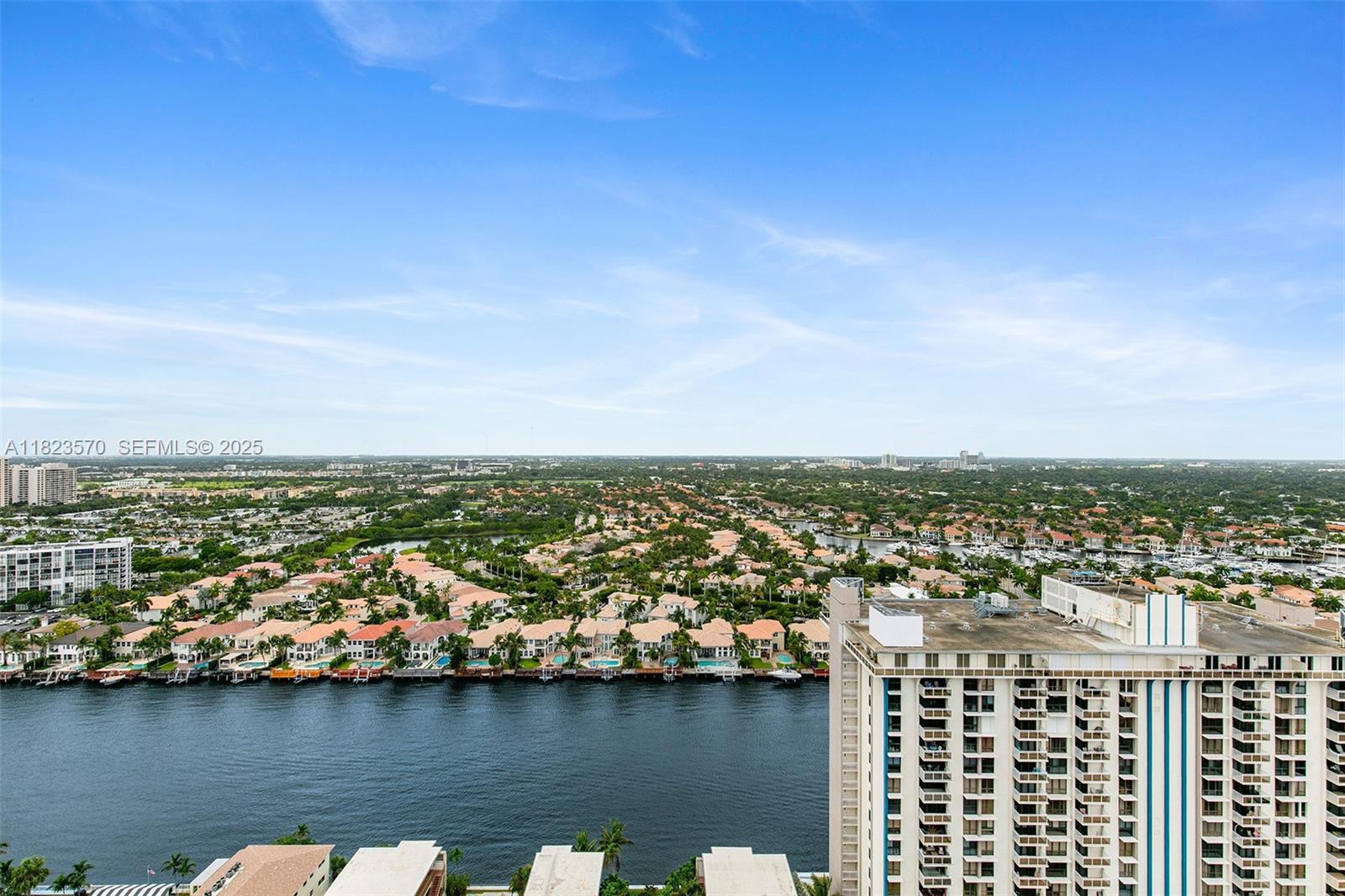 An aerial view shows a waterfront residential area with a high-rise building in the foreground — 2101 S Ocean Dr # 2707, Hollywood FL 33019, HOLLYWOOD, FL