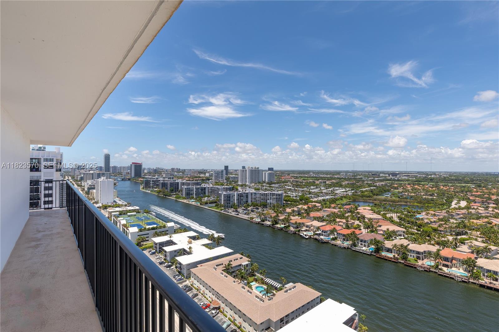A high-angle view from a balcony overlooks a canal, residential buildings, and a city skyline — 2101 S Ocean Dr # 2707, Hollywood FL 33019, HOLLYWOOD, FL
