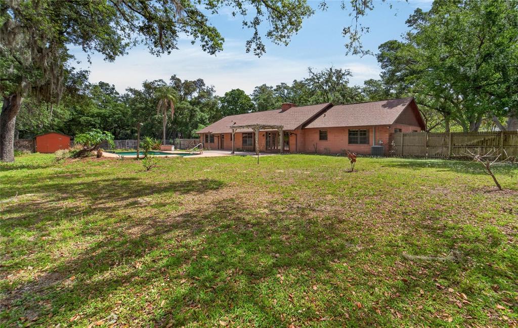 A brick house with a pool and a large backyard surrounded by mature trees — 12506 SHADOW RUN BOULEVARD, RIVERVIEW, FL