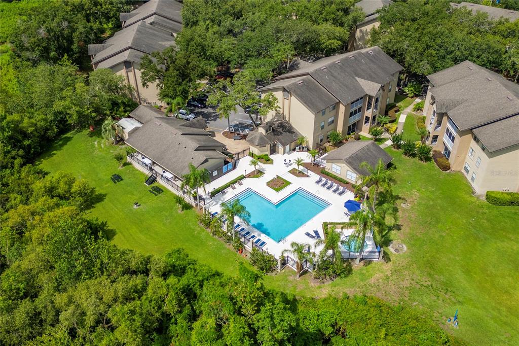 An aerial view shows an apartment complex with a swimming pool, hot tub, and landscaping — 627 DORY LANE UNIT 304, ALTAMONTE SPRINGS, FL