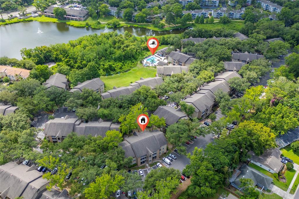An aerial view shows a multi-building apartment complex with a pool and a lake — 627 DORY LANE UNIT 304, ALTAMONTE SPRINGS, FL