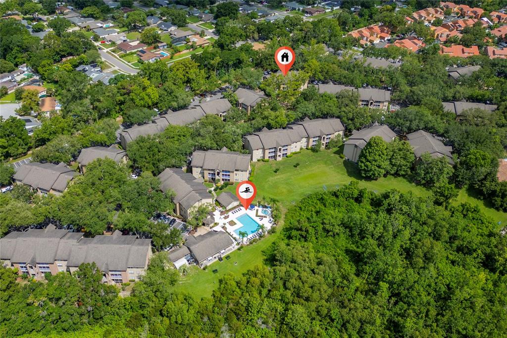 An aerial view shows a multi-building apartment complex with a central swimming pool area — 627 DORY LANE UNIT 304, ALTAMONTE SPRINGS, FL