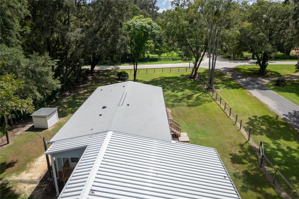 An aerial view shows a house roof, a small shed, and a fenced yard with trees — 10015 NW 45TH AVENUE, OCALA, FL