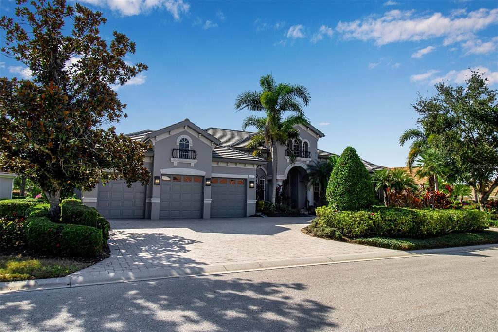 A gray, single-story house with a three-car garage and a paved driveway — 8116 LONE TREE GLEN, LAKEWOOD RANCH, FL