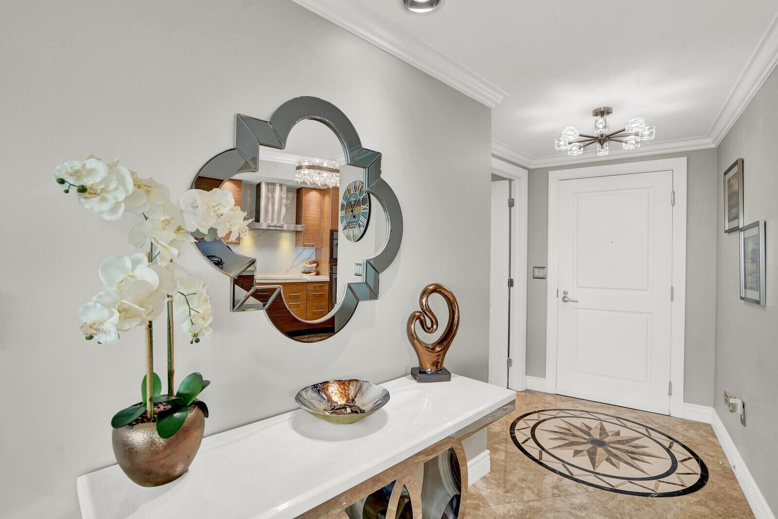 A foyer features a white console table, a decorative mirror, and a tiled floor inlay — 1 N Ocean Boulevard # 814, Pompano Beach FL 33062, POMPANO BEACH, FL