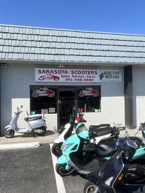The exterior of a commercial building features a sign for Sarasota Scooters and parked scooters — 853 US HIGHWAY 41 BYPASS S UNIT A, VENICE, FL