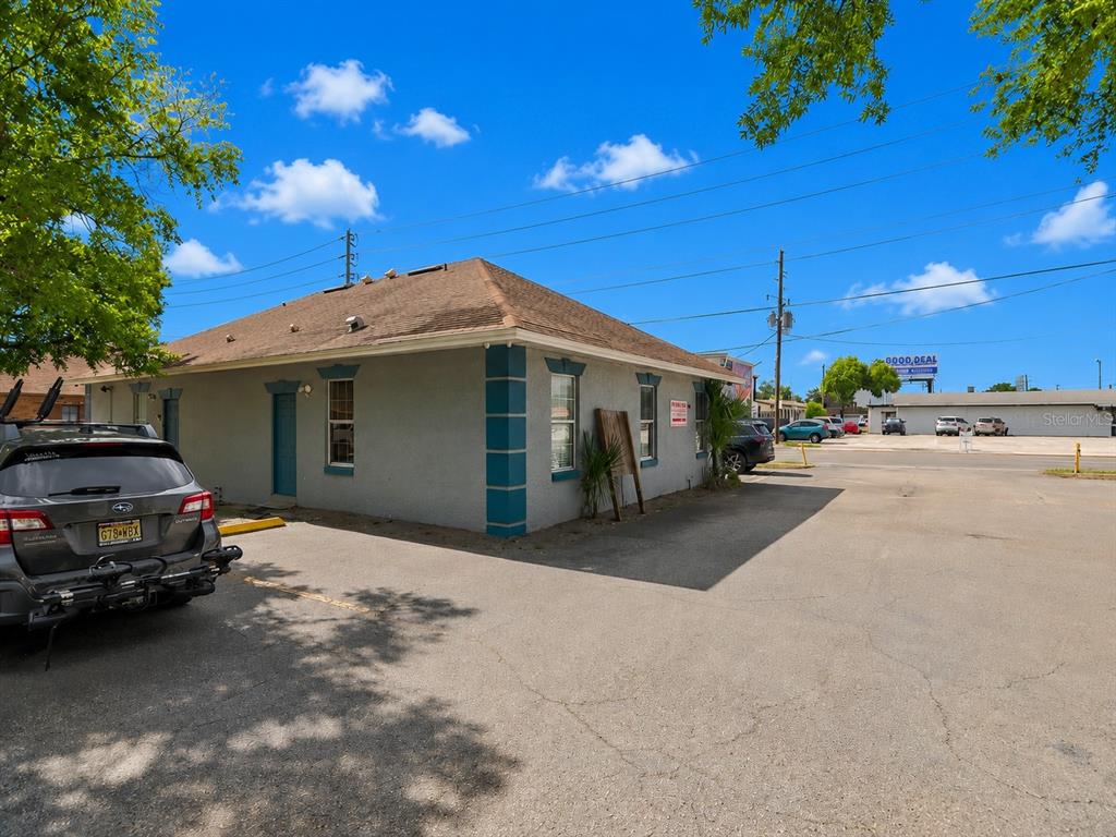 A gray, single-story commercial building with teal corner accents sits in a paved parking lot — 631 E OAK RIDGE ROAD, ORLANDO, FL