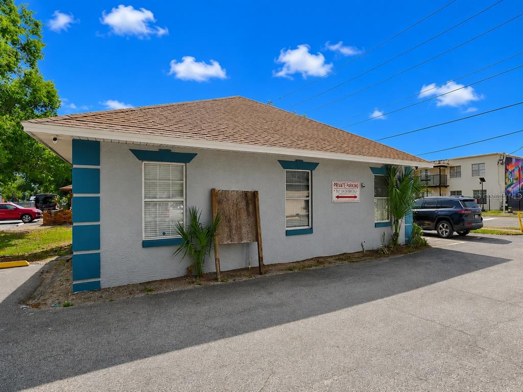 A single-story building with gray stucco walls, blue trim, and a brown shingled roof — 631 E OAK RIDGE ROAD, ORLANDO, FL