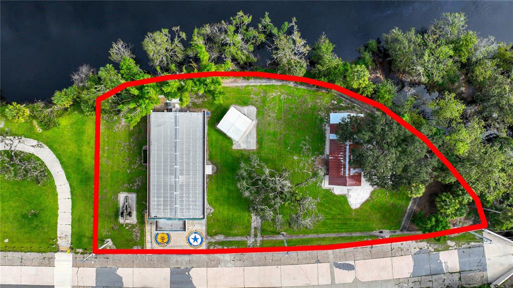 An aerial view shows a building and two smaller structures on a grassy lot — 2124 NW AMERICAN LEGION DRIVE, ARCADIA, FL