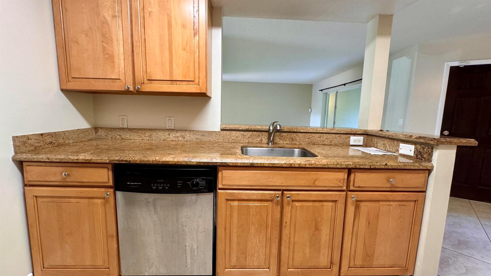 A kitchen features light wood cabinets, granite countertops, a stainless steel sink, and a dishwasher — 815 W Boynton Beach Boulevard # 105, Boynton Beach FL 33426, BOYNTON BEACH, FL