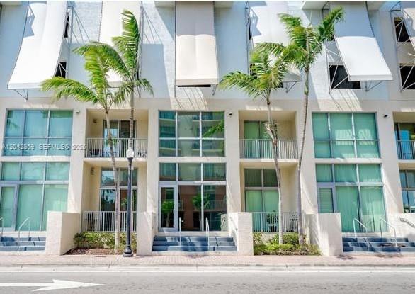 A multi-story residential building exterior features glass balconies, large windows, and palm trees — 140 S Dixie Hwy, Hollywood FL 33020, HOLLYWOOD, FL