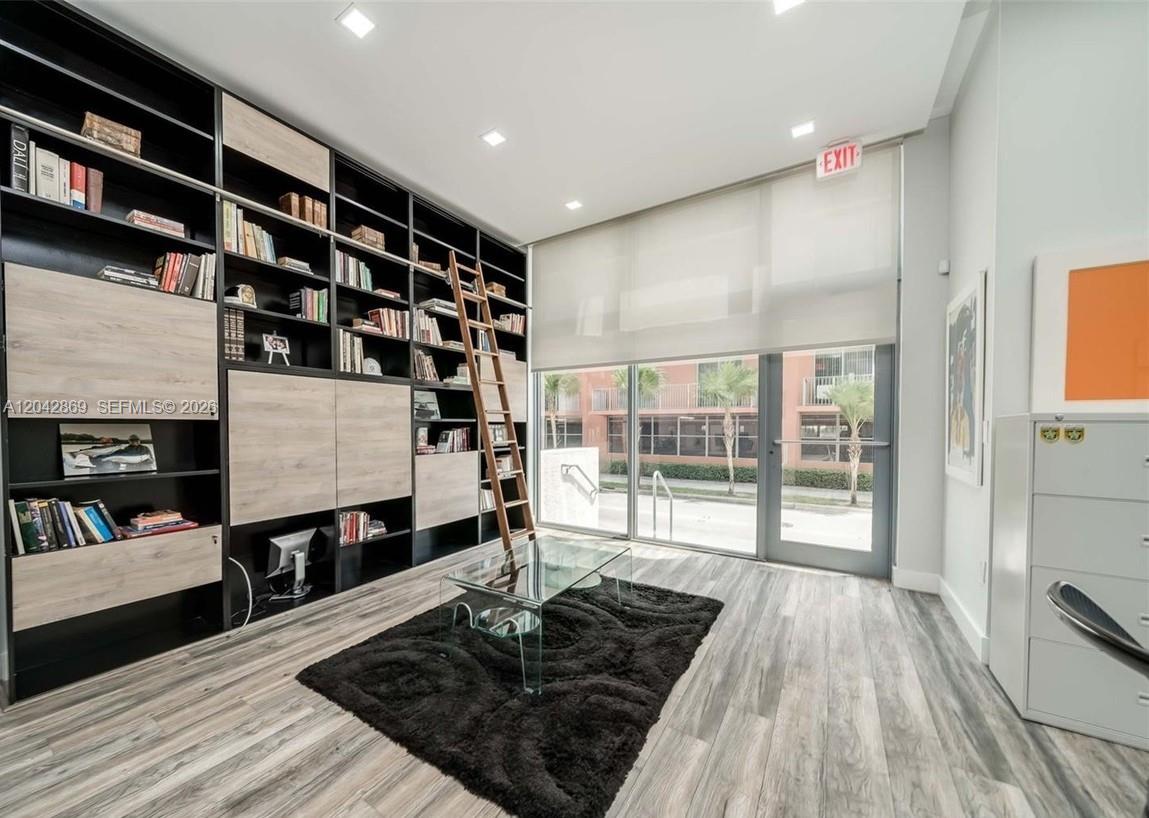 A modern office or library features a floor-to-ceiling bookshelf with a rolling ladder — 140 S Dixie Hwy, Hollywood FL 33020, HOLLYWOOD, FL