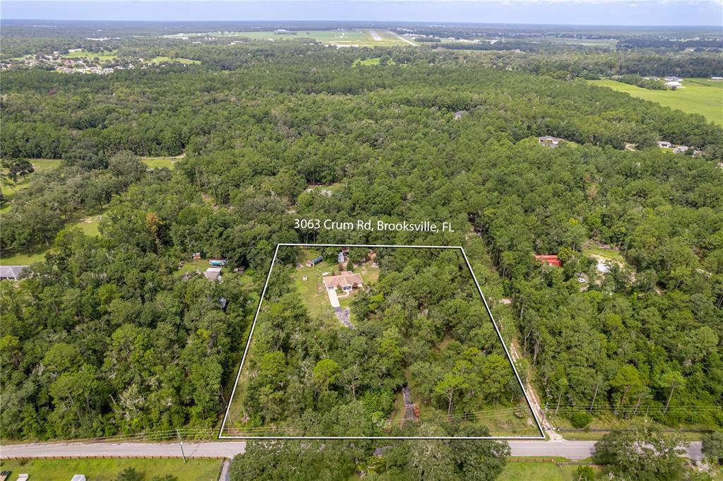 An aerial view shows a house situated on a large, wooded lot — 3063 CRUM ROAD, BROOKSVILLE, FL