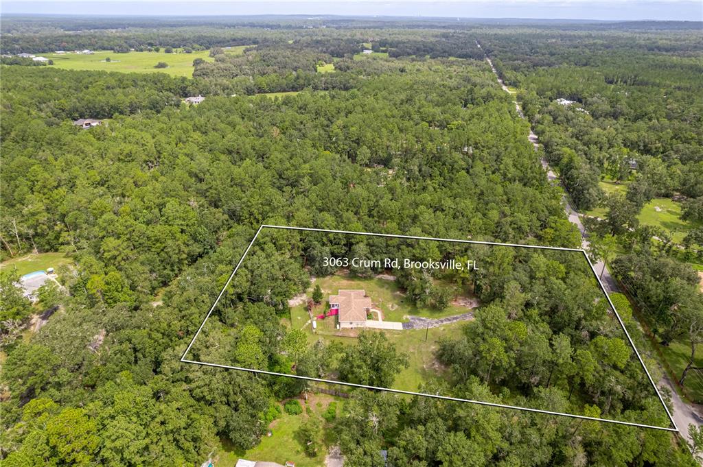 An aerial view shows a house situated on a large, wooded lot — 3063 CRUM ROAD, BROOKSVILLE, FL