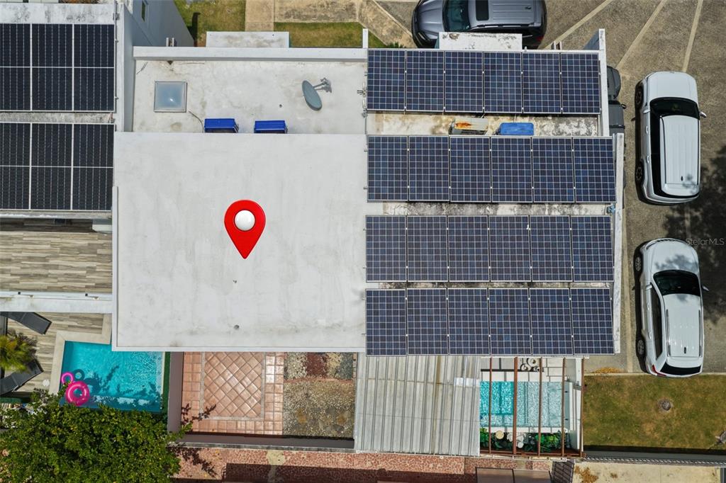 An aerial view shows a flat roof with solar panels, a pool, and parked cars — 111 CALLE DONCELLA UNIT TH2, SAN JUAN, PR