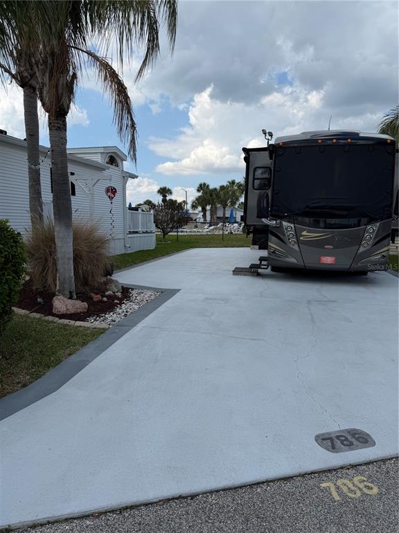 A recreational vehicle is parked on a concrete pad next to a white mobile home — 9000 US HWY 192 UNIT 786, CLERMONT, FL