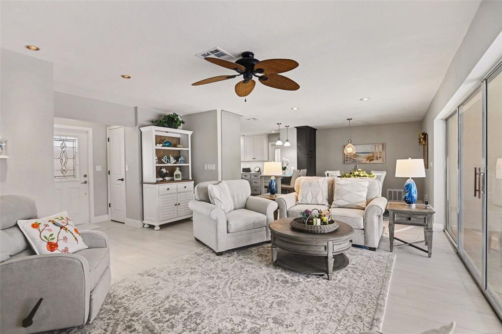 A living room features light gray walls, a ceiling fan, and an open-concept kitchen area — 543 BELVEDERE COURT, PUNTA GORDA, FL