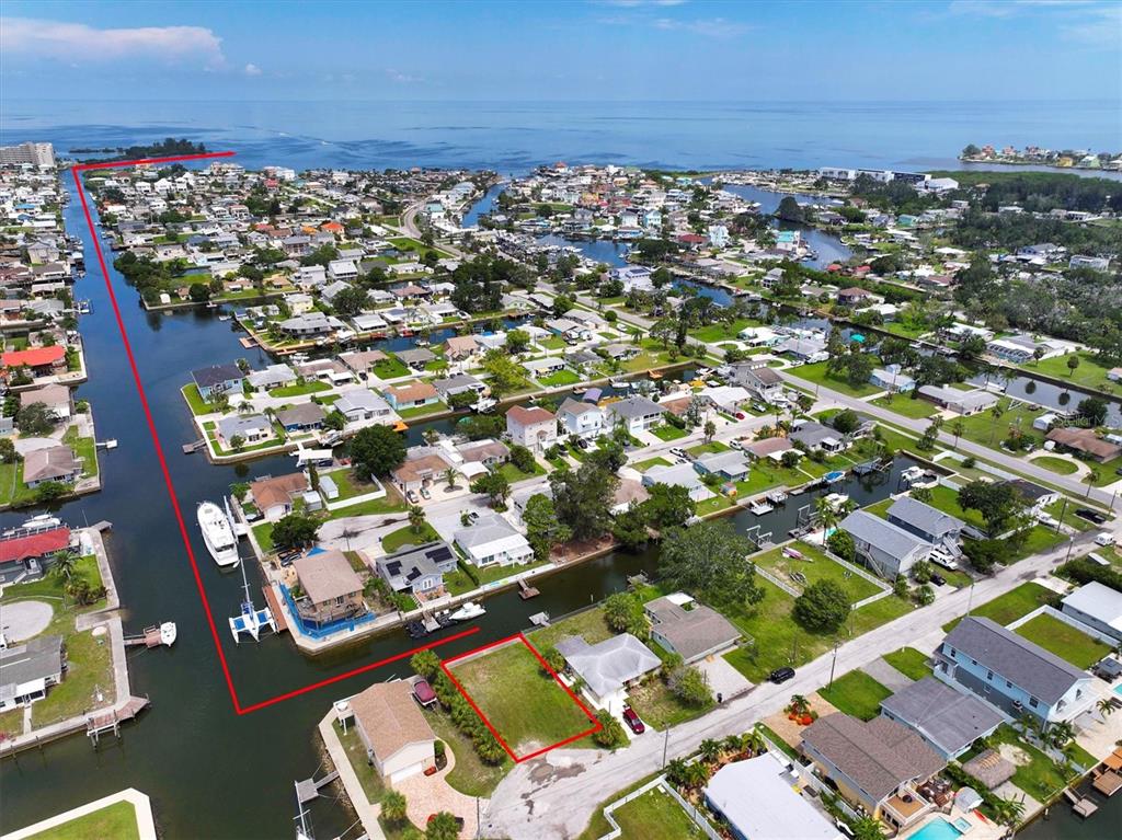 An aerial view shows a vacant waterfront lot outlined in red within a residential neighborhood — 13901 DULEY AVENUE, HUDSON, FL