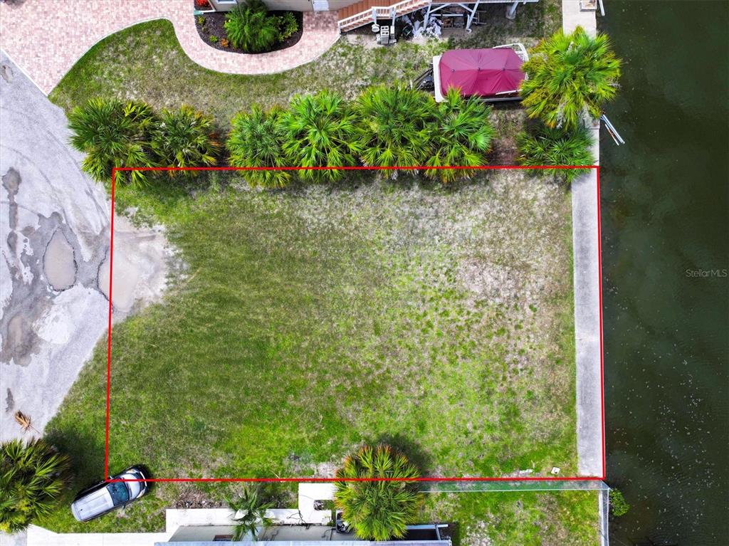 An aerial view shows a rectangular waterfront lot outlined in red next to a paved road — 13901 DULEY AVENUE, HUDSON, FL
