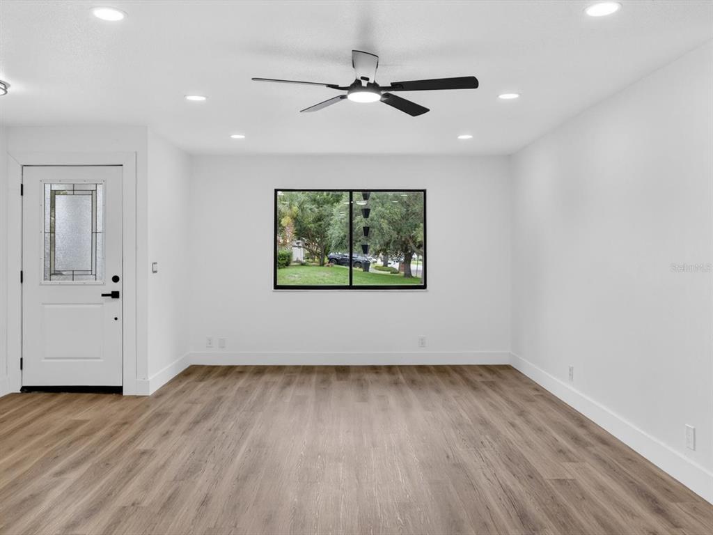 A bright room with white walls, wood-look flooring, a ceiling fan, and a single window — 308 S SHADOW BAY DRIVE, ORLANDO, FL