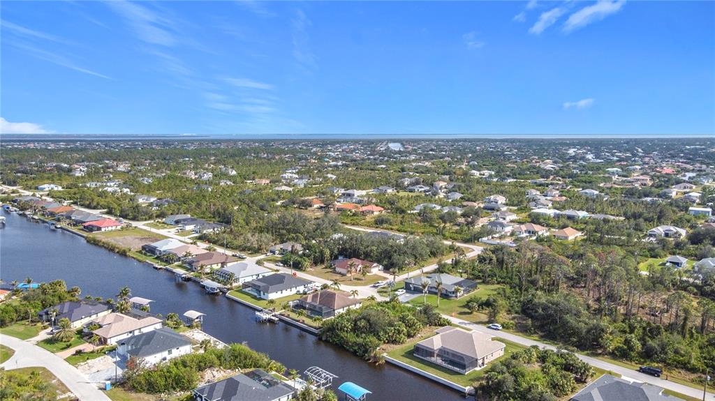 An aerial view shows residential houses along a canal in a suburban neighborhood — 9177 SANTA LUCIA DRIVE, PORT CHARLOTTE, FL