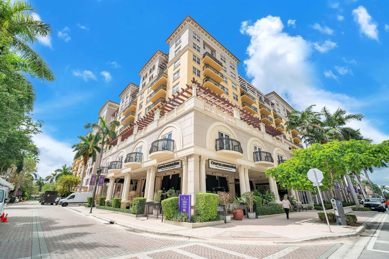 A multi-story building with a restaurant on the ground floor features balconies and palm trees — 101 Plaza Real S # 829, Boca Raton FL 33432, BOCA RATON, FL