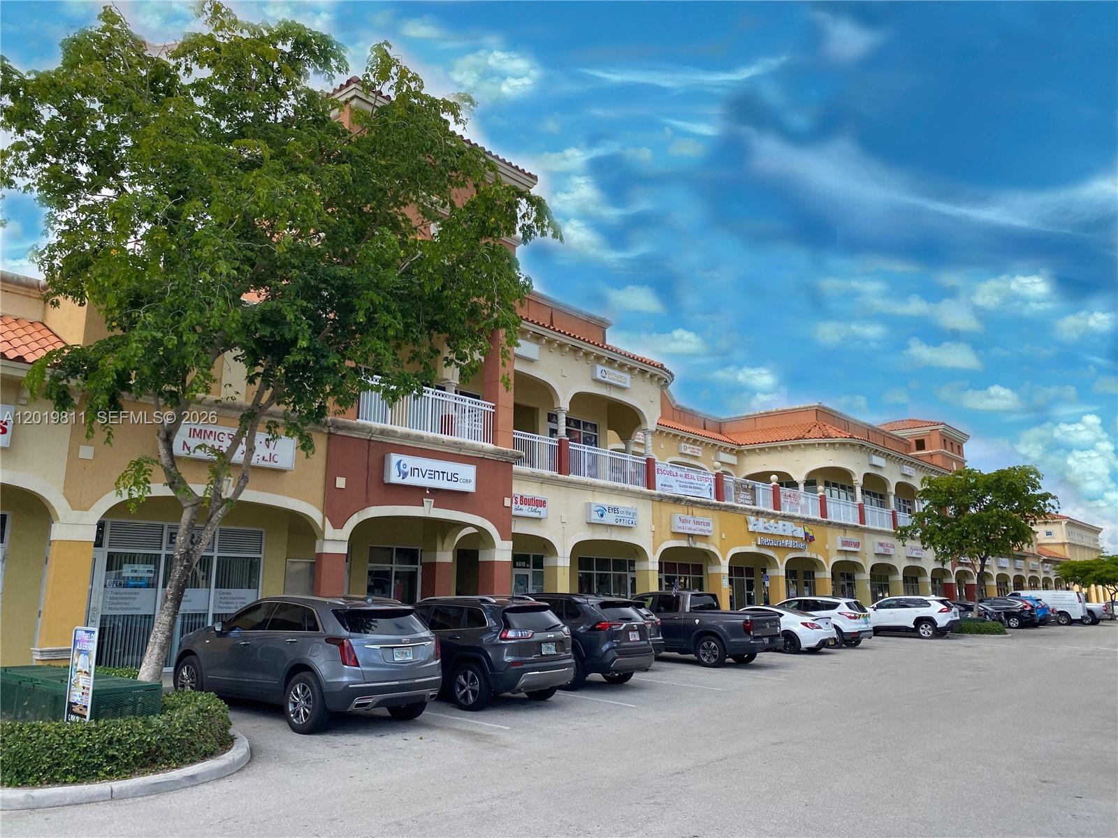 A multi-story commercial strip mall features a parking lot and several storefronts under a blue sky — 6630 Stirling Rd, Davie FL 33024, DAVIE, FL