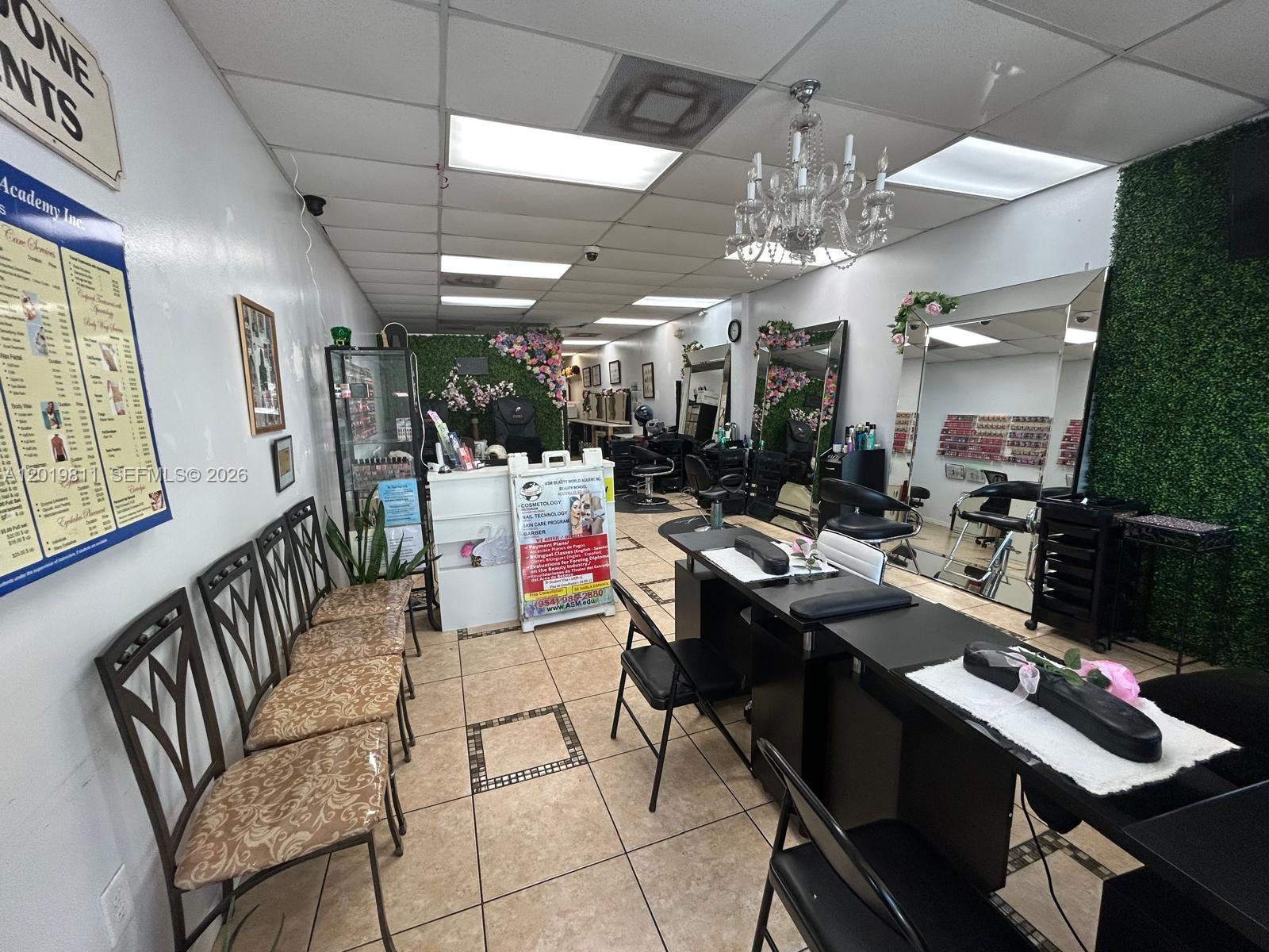 A beauty salon features tile flooring, a chandelier, nail stations, and wall-mounted mirrors — 6630 Stirling Rd, Davie FL 33024, DAVIE, FL