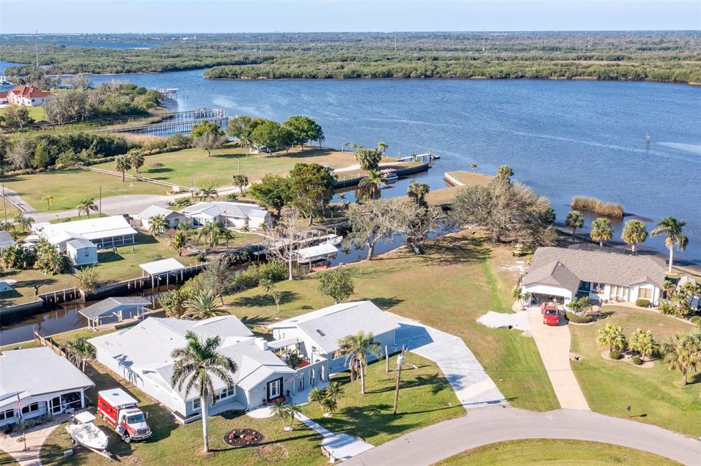 An aerial view shows waterfront houses with boat docks, palm trees, and a large canal — 541 RIDGECREST DRIVE, PUNTA GORDA, FL