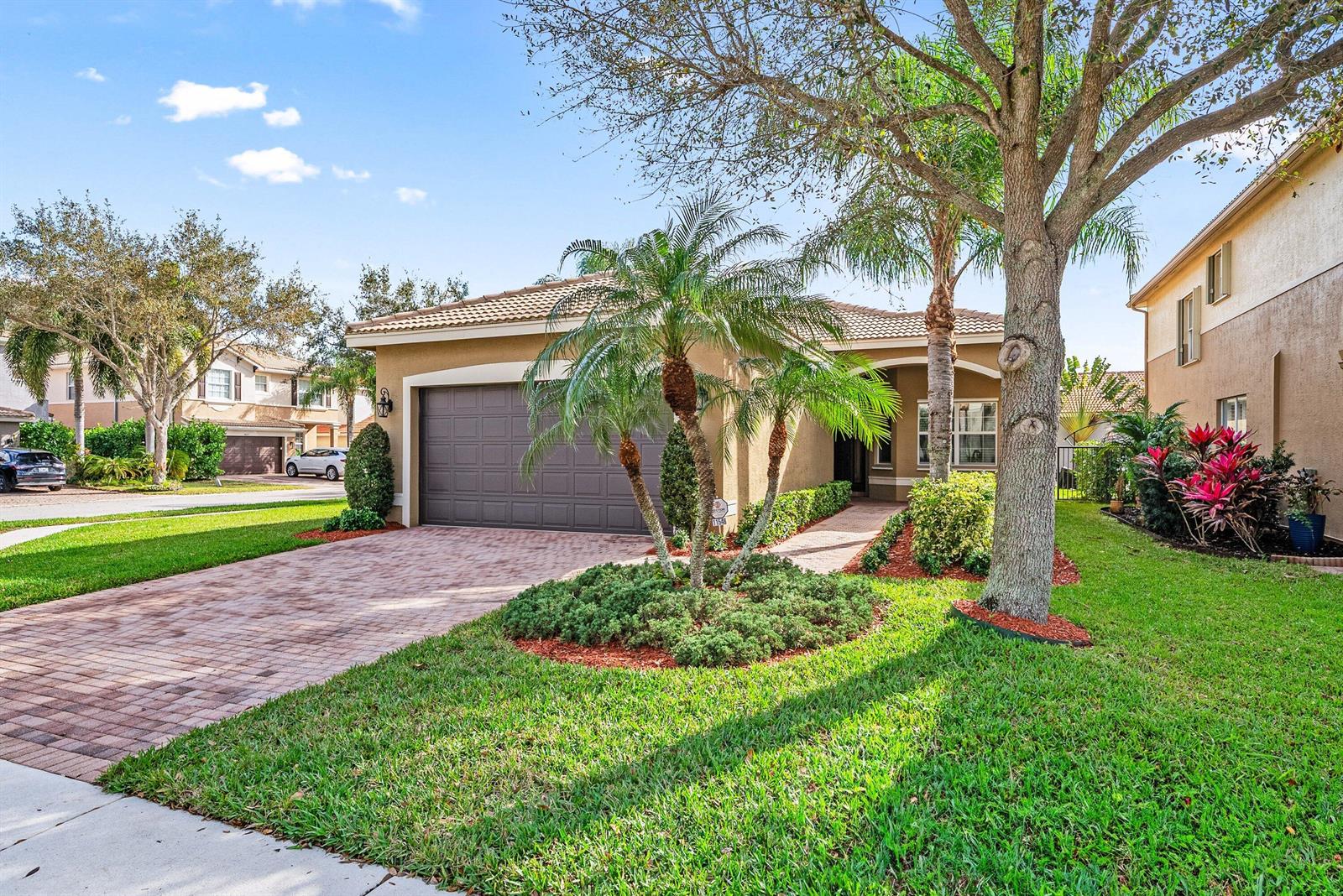 A single-story house with a brown garage, paver driveway, and palm trees in the front yard — 11546 Ponywalk Trail, Boynton Beach FL 33473, BOYNTON BEACH, FL