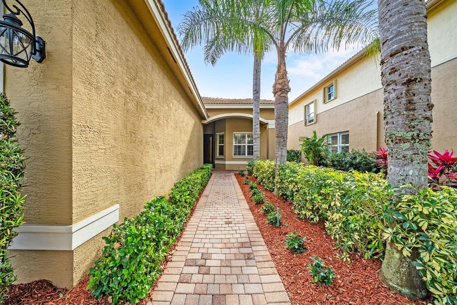A brick walkway leads to the front entrance of a house flanked by palm trees — 11546 Ponywalk Trail, Boynton Beach FL 33473, BOYNTON BEACH, FL