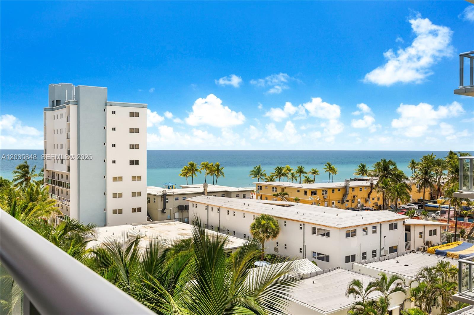 An elevated view shows a coastal scene with a tall building, low-rise structures, and palm trees — 777 N Ocean Dr # N516, Hollywood FL 33019, HOLLYWOOD, FL