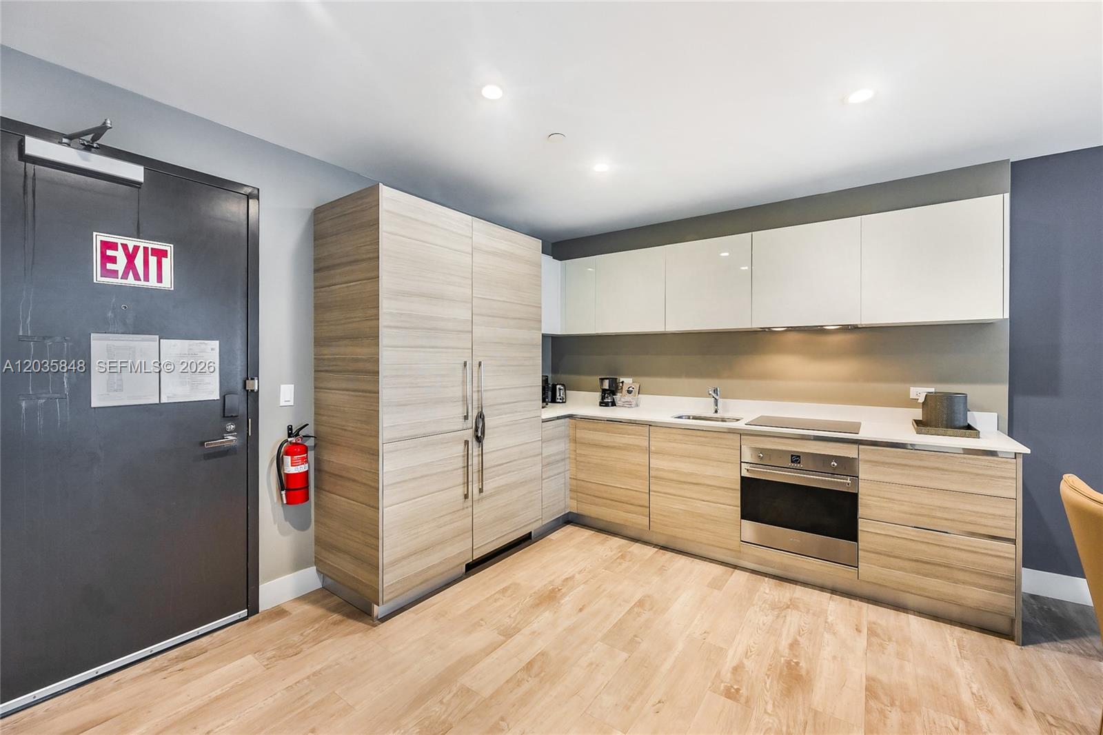 A modern kitchenette features light wood cabinetry, white countertops, and a stainless steel oven — 777 N Ocean Dr # N516, Hollywood FL 33019, HOLLYWOOD, FL