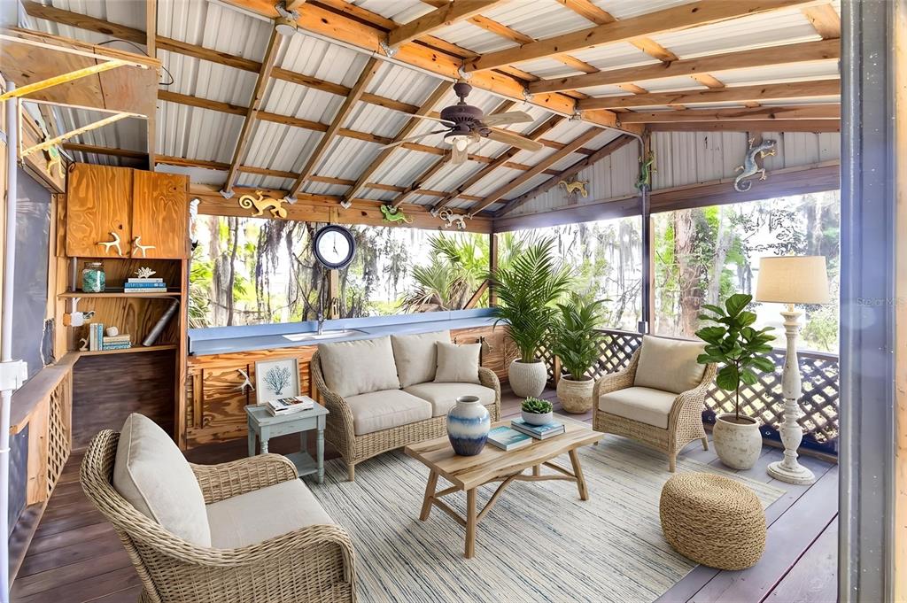 A screened-in porch features wicker furniture, a wooden coffee table, and a metal roof — 14014 SE 201ST TERRACE, HAWTHORNE, FL