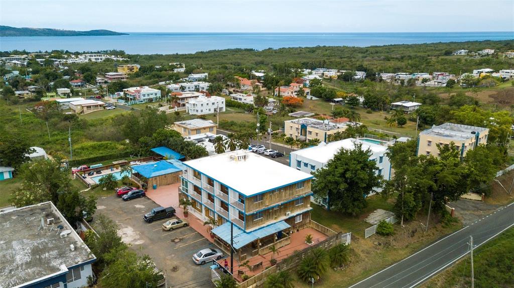An aerial view shows a multi-story building with a parking lot and surrounding coastal neighborhood — ST 307 KM 7.4, BOQUERON, PR