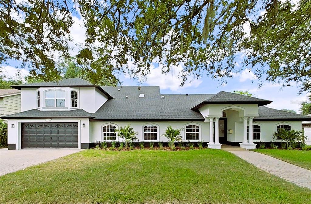 A white two-story house with a dark roof, a garage, and a columned entryway — 3322 SCHEFFLERA ROAD, TAMPA, FL