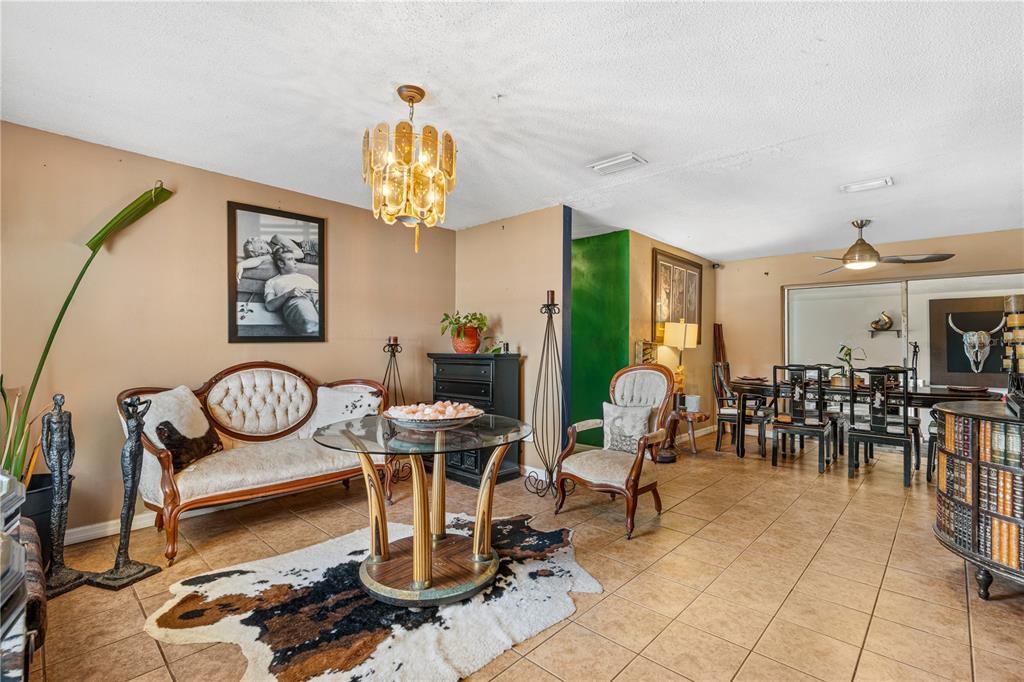 A living and dining area with tile floors, a cowhide rug, and a glass table — 808 KATHY STREET, DAYTONA BEACH, FL