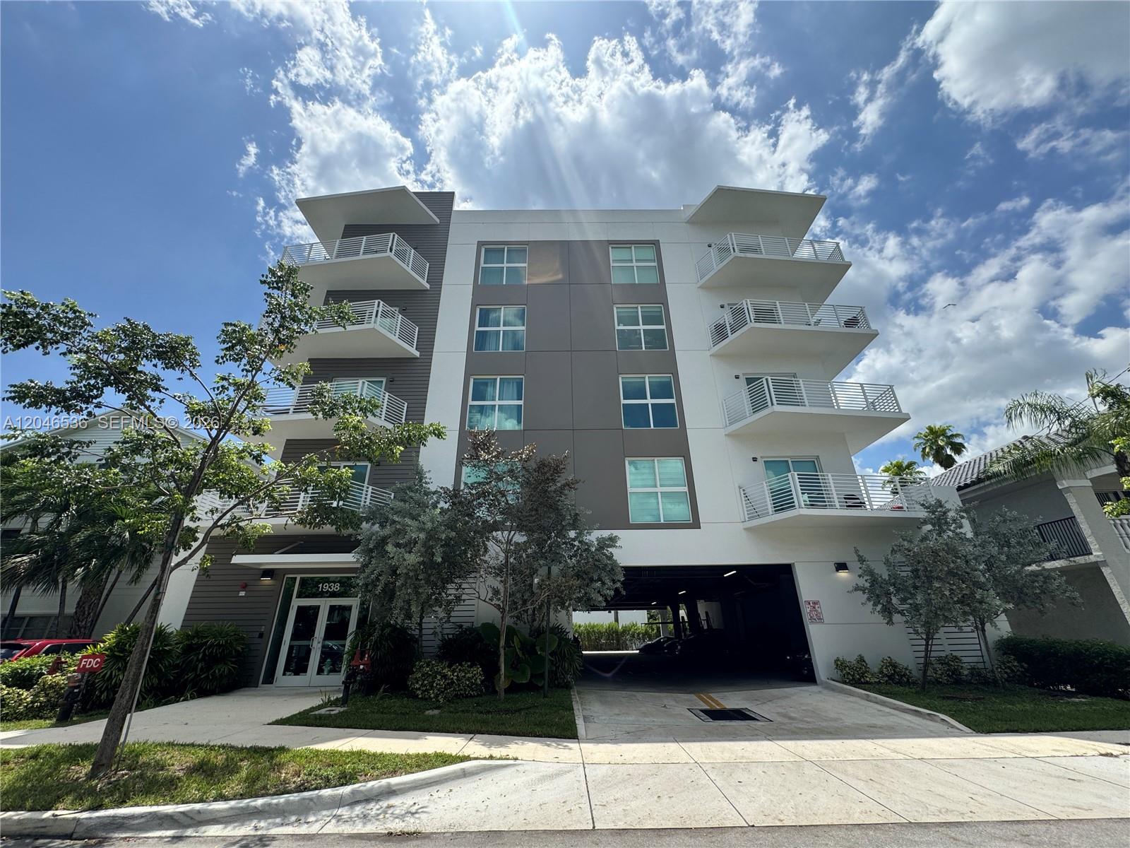 A modern four-story apartment building features white and gray exterior walls with private balconies — 1938 Jackson St # 503, Hollywood FL 33020, HOLLYWOOD, FL