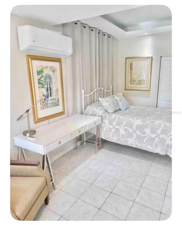 A bedroom features a white desk, a metal-framed bed, and a wall-mounted air conditioning unit — 274 CALLE PINTA UNIT 1A, SAN JUAN, PR